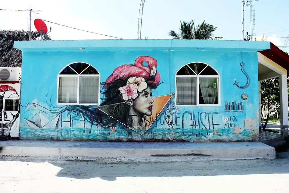 Mural de una mujer con flamenco en una casa de Holbox